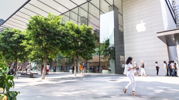 คนเดินเท้ากำลังเดินผ่านแฟล็กชิปสโตร์ของ Apple ในสิงคโปร์บนถนน Orchard Road (ถนนออร์ชาร์ด)