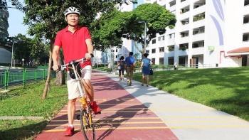 A man with a bicycle on the cycling path