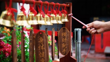 Một tín đồ gõ chuông tại Chùa Thian Hock Keng ở Singapore