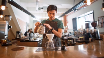 Một thợ pha chế làm cà phê phin giấy (drip coffee) ở Chye Seng Huat Hardware Coffee Bar