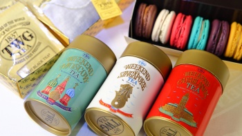 Hình chụp cận cảnh các vị trà của TWG trên nền các loại bánh macaron khác nhau