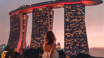 Hình chụp góc rộng cô gái mặc váy trên nền Marina Bay Sands