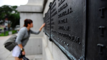Một du khách đang đọc những dòng chữ khắc trên bia của các liệt sĩ đã hy sinh tại Tượng đài Cenotaph