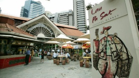 Ảnh chụp từ bên ngoài với người dân đang ăn uống và biểu tượng của Khu ăn uống Lau Pa Sat