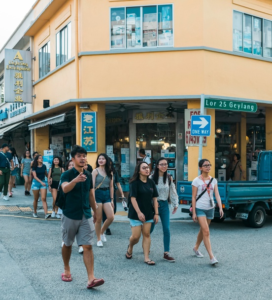 Cai Yinzhou và nhóm du khách đi bộ trên đường phố Geylang Lorong 25