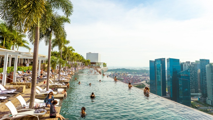 Quang cảnh hồ bơi vô cực trên Marina Bay Sands SkyPark, với tầm nhìn ra đường chân trời Singapore vào ban đêm.